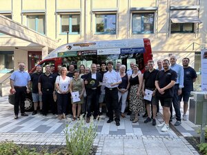 Bild vergr&ouml;&szlig;ern: Vor einem Feuerwehrauto stehen viele Leute. Sie haben das mit ihren Anzeigen bezahlt.
