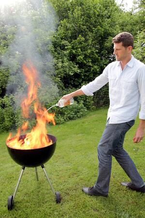 Bild vergrößern: Mann mit Feuer beim Grillen